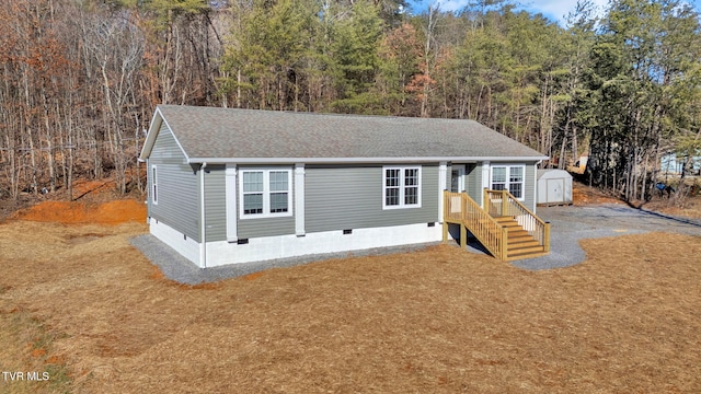 view of front facade with a front lawn and a storage unit