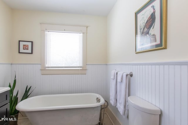 bathroom featuring toilet, vanity, and a bath