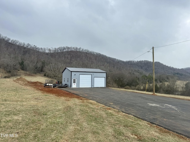 garage featuring a mountain view and a yard