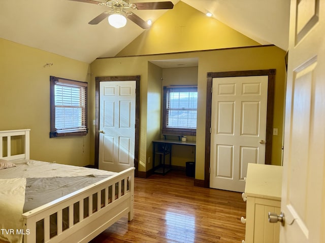 bedroom with hardwood / wood-style flooring, ceiling fan, lofted ceiling, and multiple windows