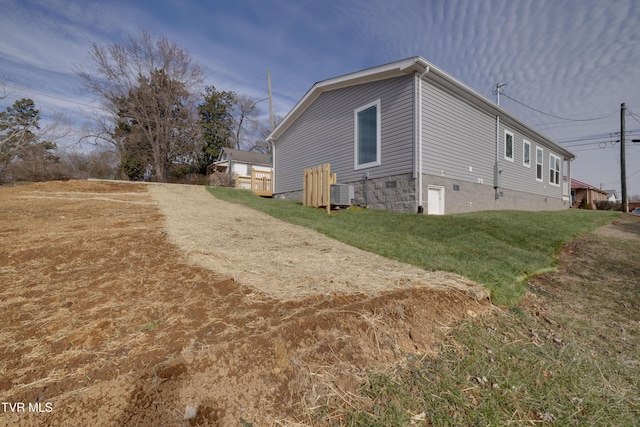 view of side of home featuring a yard and central air condition unit