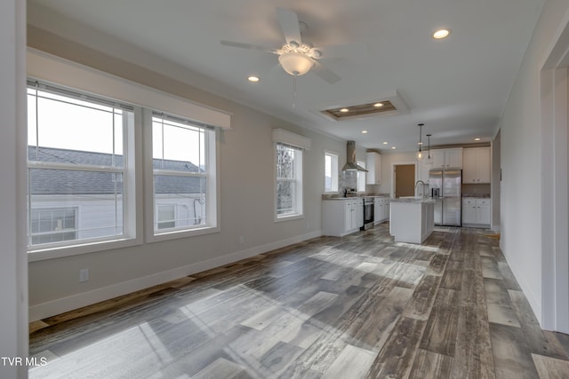 unfurnished living room featuring wood-type flooring and ceiling fan