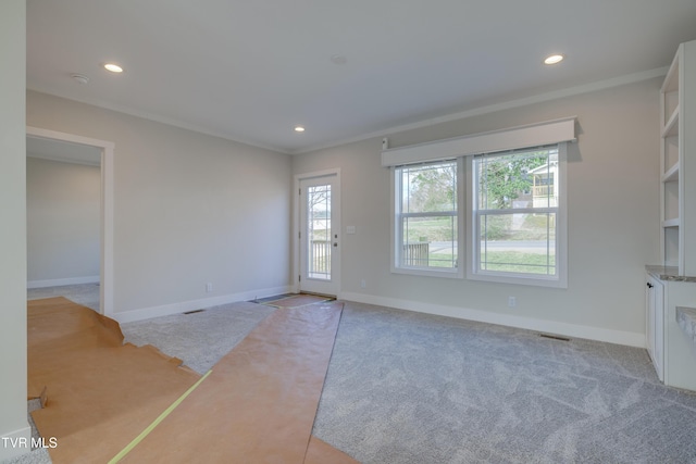 interior space with ornamental molding and light colored carpet