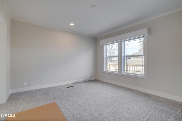 unfurnished room with ornamental molding and carpet flooring