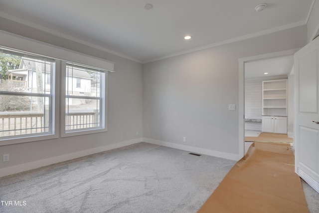 spare room featuring crown molding and light colored carpet