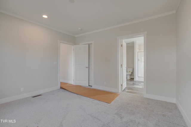 carpeted spare room featuring crown molding