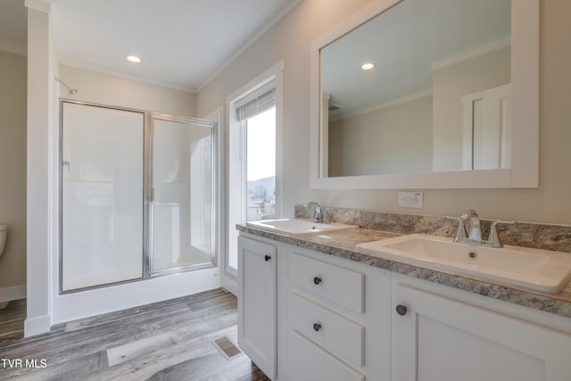 bathroom with hardwood / wood-style flooring, vanity, crown molding, and an enclosed shower