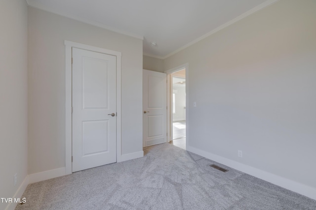 unfurnished bedroom with light colored carpet and ornamental molding