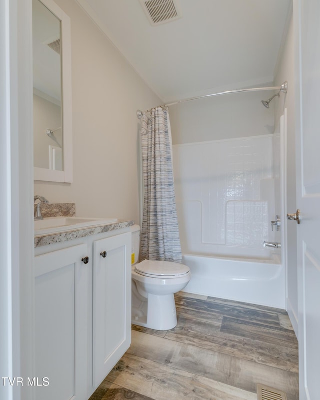 full bathroom with shower / tub combo with curtain, wood-type flooring, toilet, and vanity