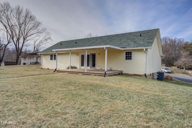 rear view of house featuring a wooden deck, a lawn, and central air condition unit