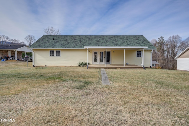 rear view of house with a wooden deck and a yard