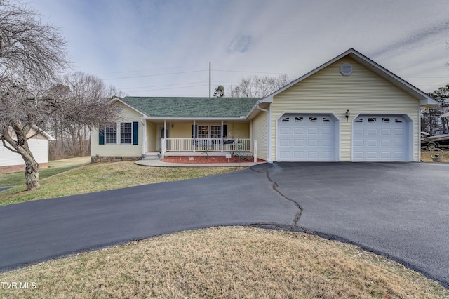 ranch-style house featuring a garage, a front yard, and covered porch