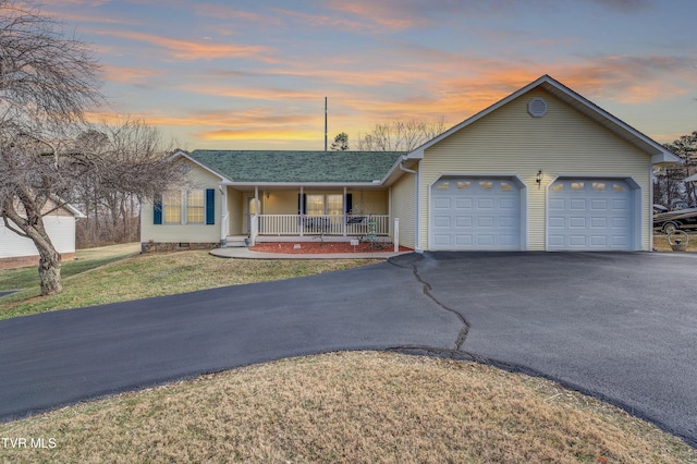 single story home with a yard, a garage, and a porch