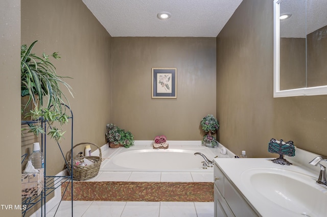 bathroom featuring vanity, a bath, and a textured ceiling