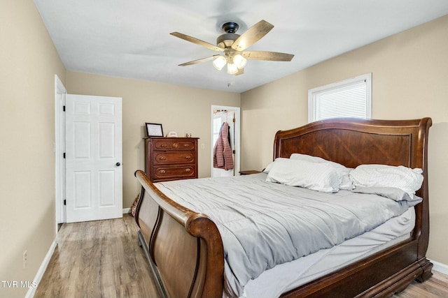 bedroom with a closet, a walk in closet, ceiling fan, and light hardwood / wood-style floors