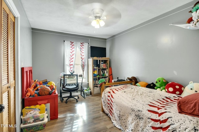 bedroom with hardwood / wood-style floors, ceiling fan, and a closet