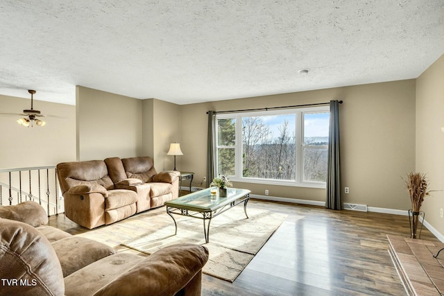 living room featuring ceiling fan, wood-type flooring, and a textured ceiling