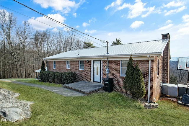 rear view of property featuring a patio area and a lawn