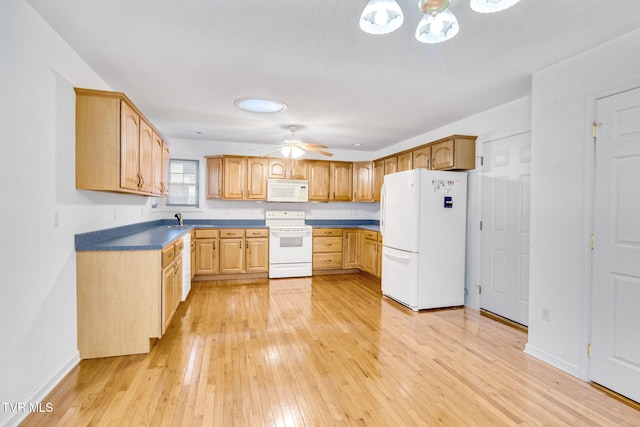 kitchen with white appliances, light brown cabinetry, sink, and light wood-type flooring