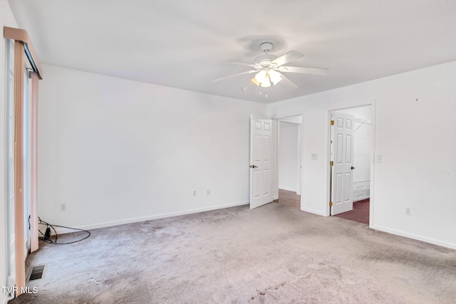 spare room with ceiling fan and dark colored carpet