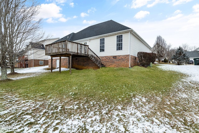 view of snowy exterior featuring a yard and a deck