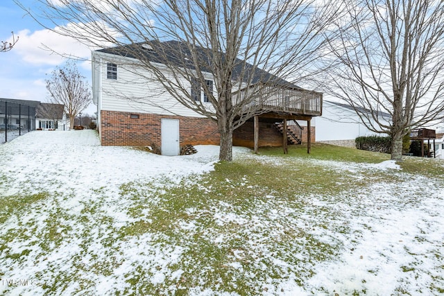 snow covered house featuring a wooden deck