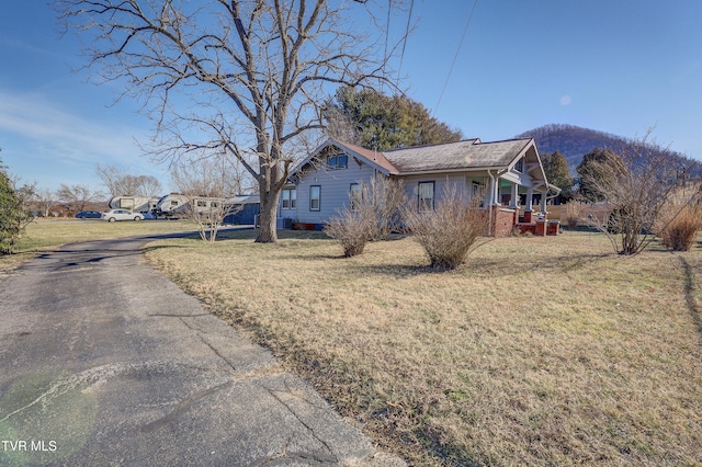 view of front of home with a mountain view and a front lawn