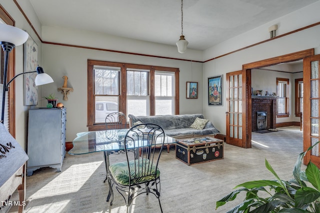 living room featuring a brick fireplace, light colored carpet, and french doors