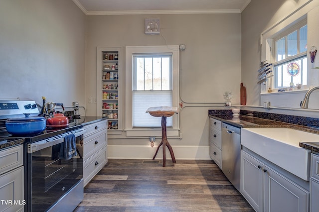 kitchen featuring appliances with stainless steel finishes, white cabinetry, sink, dark hardwood / wood-style flooring, and crown molding