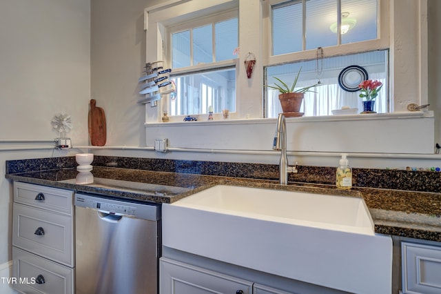 kitchen with white cabinetry, dishwasher, sink, and dark stone countertops