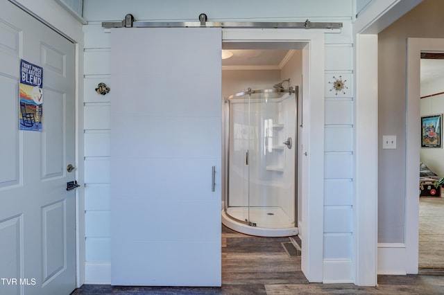 bathroom featuring hardwood / wood-style flooring, crown molding, and an enclosed shower