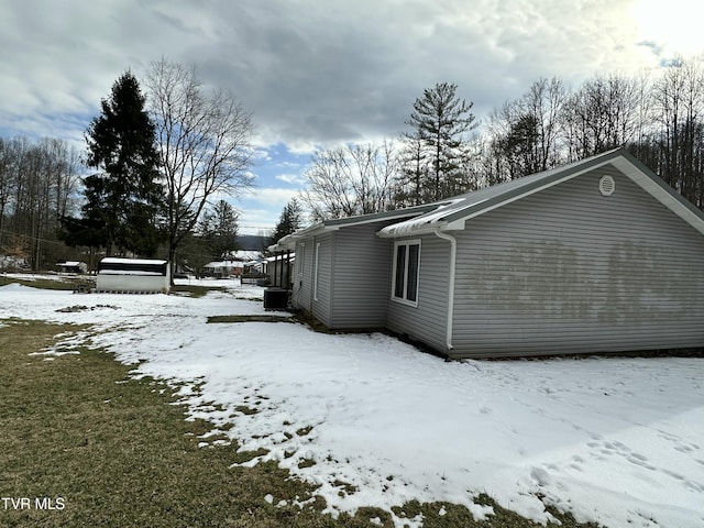 view of snow covered exterior with central AC