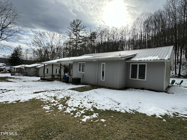 snow covered house with central AC