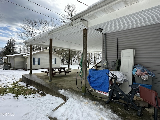 snow covered patio with an outbuilding