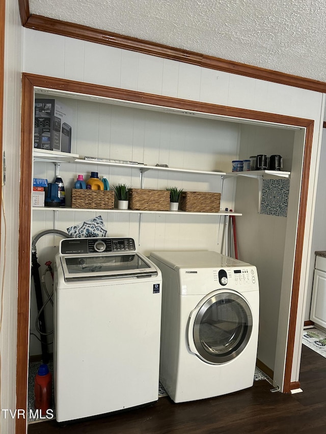 laundry area with dark wood-type flooring, ornamental molding, a textured ceiling, separate washer and dryer, and wood walls