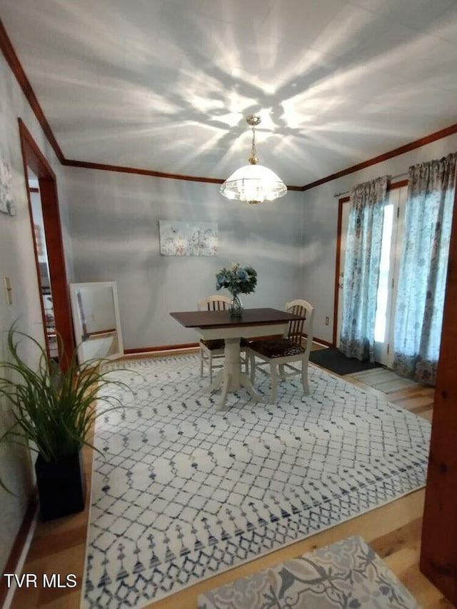 dining space with an inviting chandelier and ornamental molding