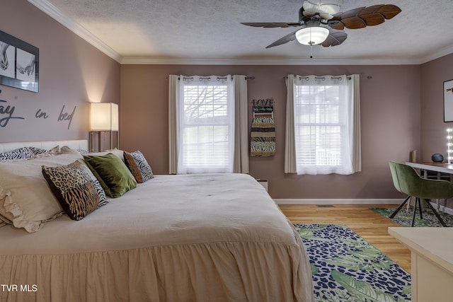 bedroom with ceiling fan, hardwood / wood-style floors, and a textured ceiling