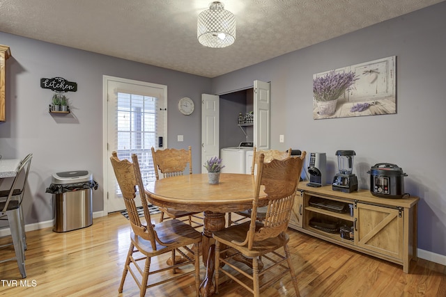 dining space featuring washer and clothes dryer, light hardwood / wood-style floors, and a textured ceiling