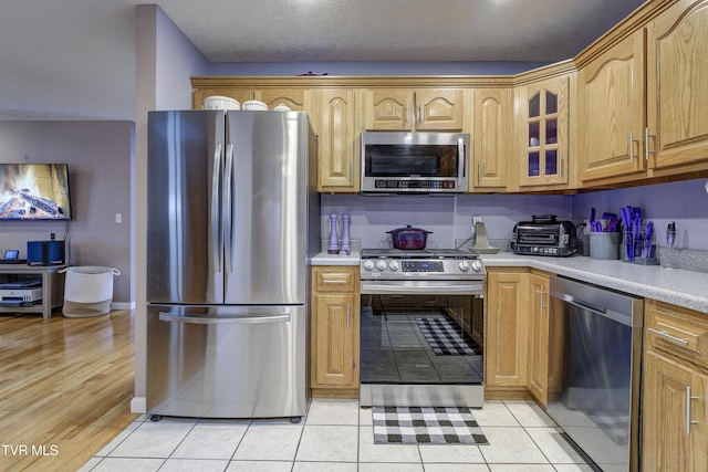 kitchen featuring stainless steel appliances and light tile patterned floors