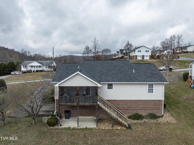 rear view of property with a sunroom and a patio area