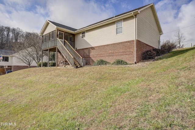 rear view of house with a lawn and a sunroom