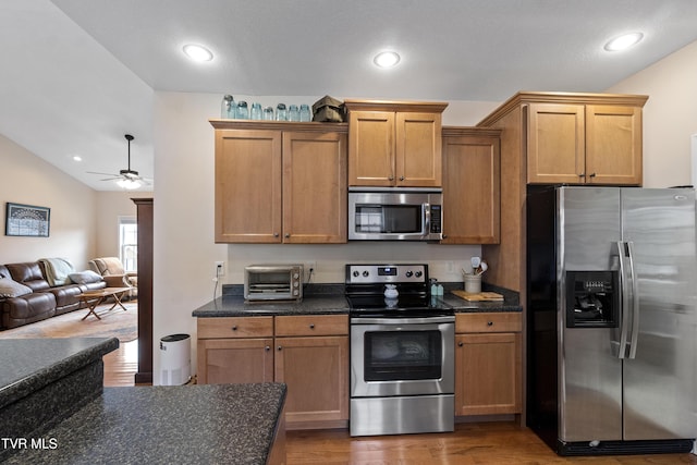 kitchen with stainless steel appliances, wood-type flooring, lofted ceiling, and ceiling fan