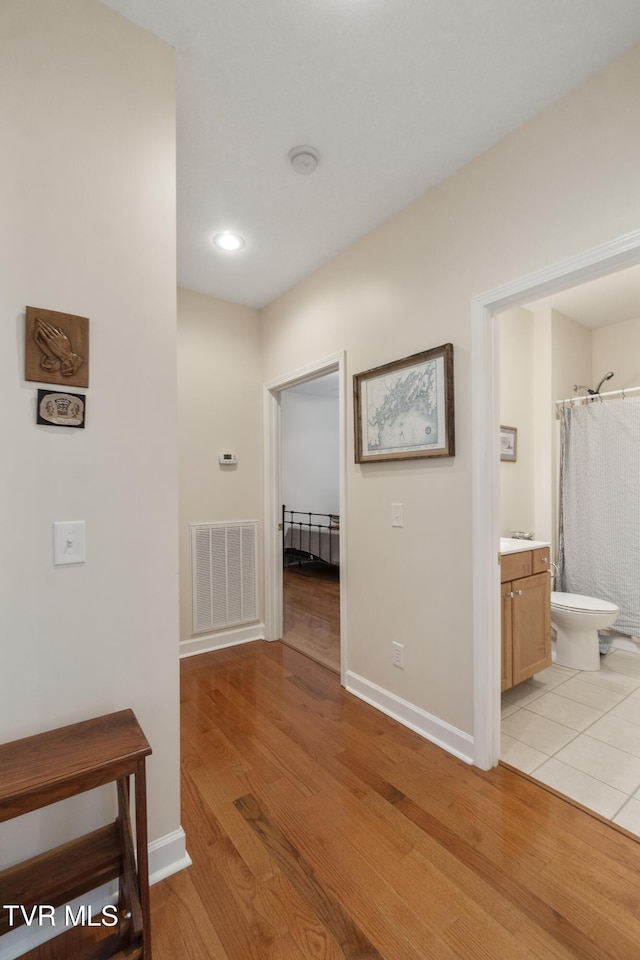 hallway with light hardwood / wood-style floors