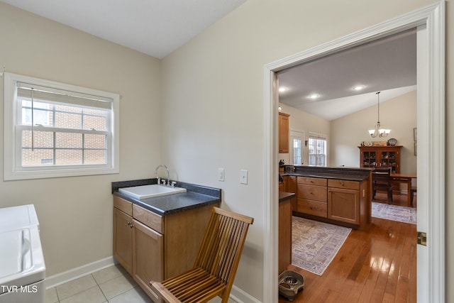 bathroom featuring vaulted ceiling, sink, hardwood / wood-style floors, and a chandelier