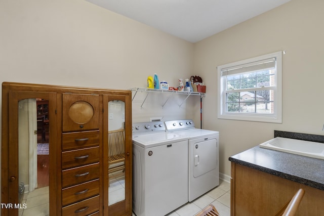 laundry room with sink, washing machine and dryer, and light tile patterned floors