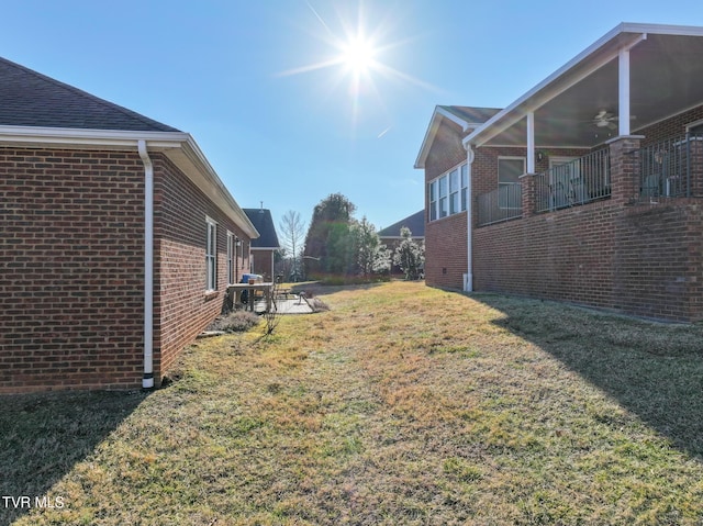 view of yard with ceiling fan and a patio