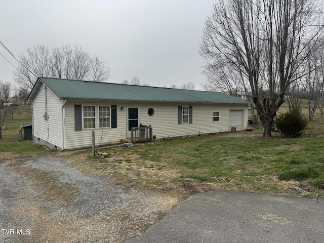 single story home featuring a front lawn, metal roof, a garage, crawl space, and driveway