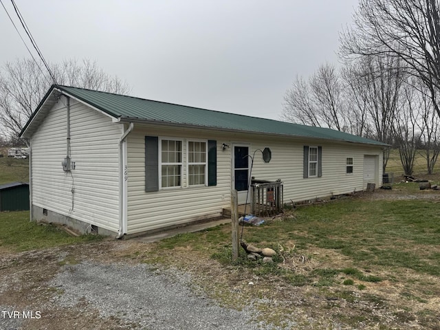 view of front of property featuring driveway, central AC, a garage, crawl space, and metal roof