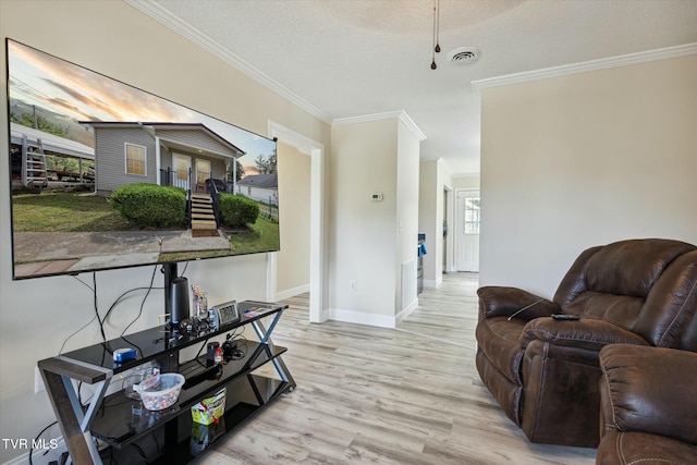 living room with crown molding, light hardwood / wood-style flooring, and a textured ceiling