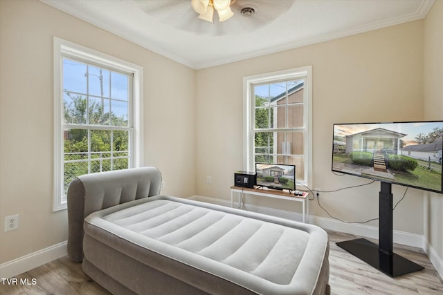 bedroom featuring ceiling fan, ornamental molding, and light hardwood / wood-style flooring